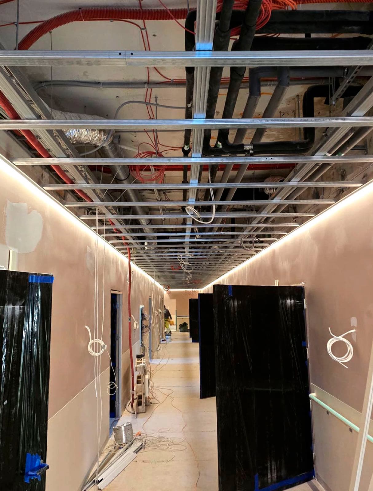 Iekaramo griestu metāla karkass ar kabeļiem un ventilāciju pirms plākšņu montāžas