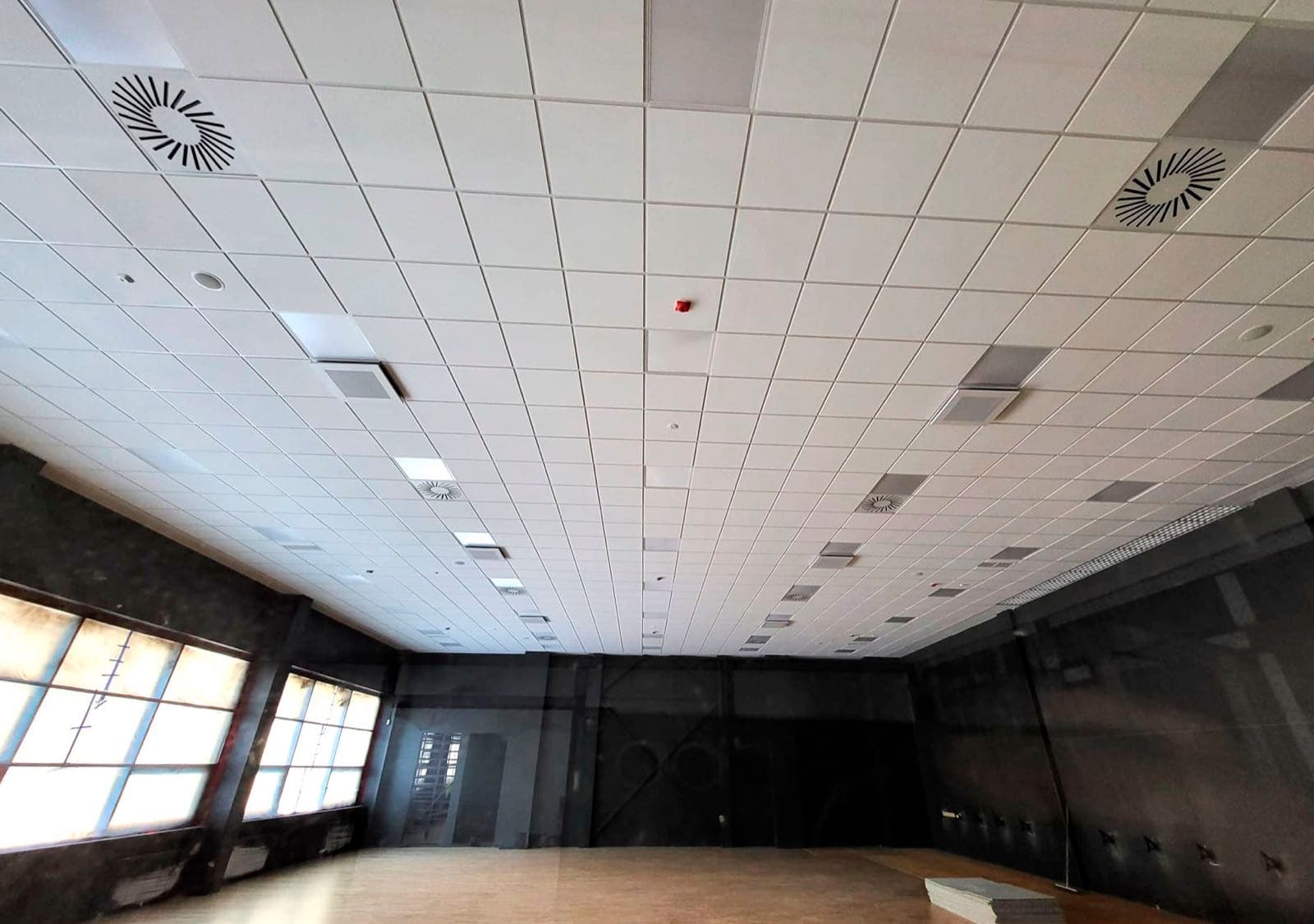 Kasešu griesti lielā zālē ar ventilācijas difuzoriem un gaismas paneļiem