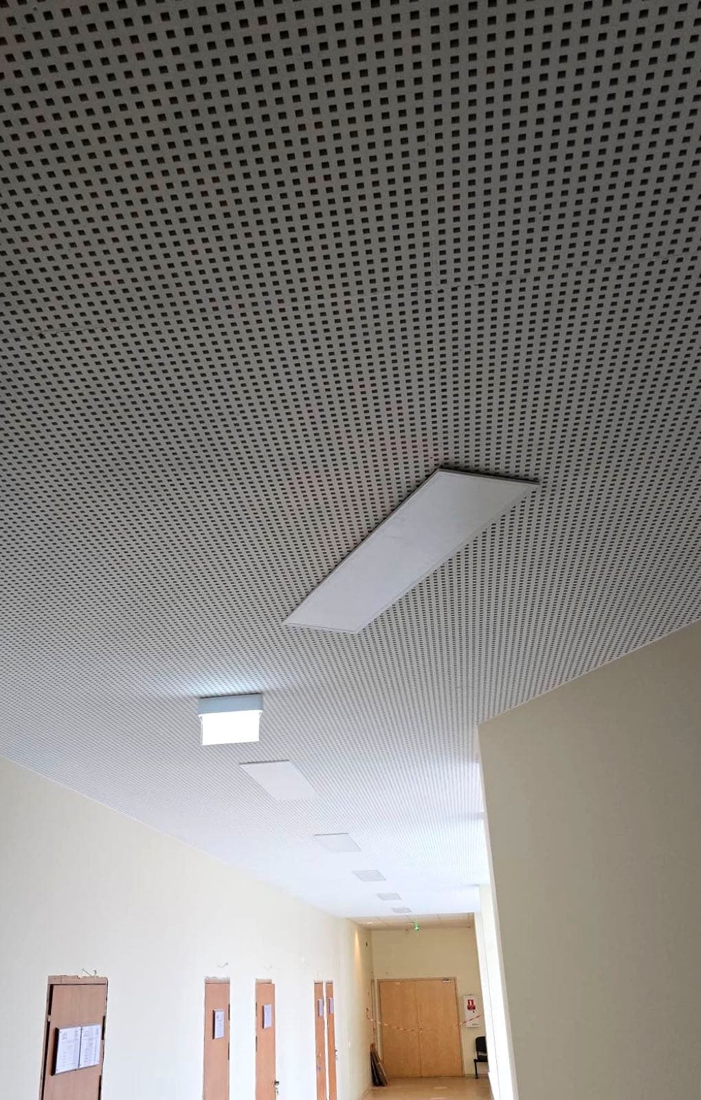 Perforēti ģipškartona griesti koridorā ar iebūvētiem lineāriem gaismekļiem